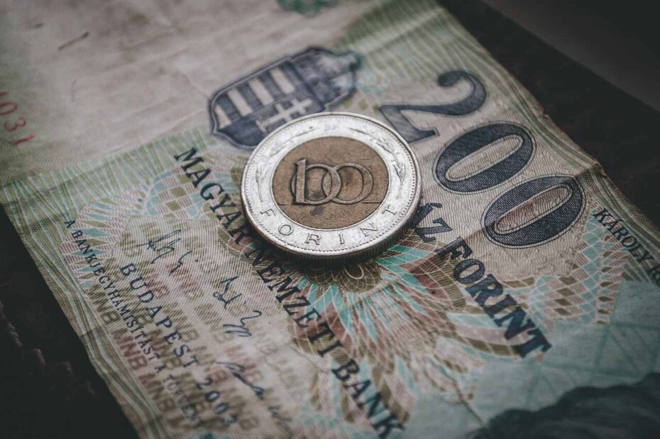 Close-up of a 100 Hungarian Forint coin on top of a 200 Forint banknote, illustrating Budapest currency for travelers.