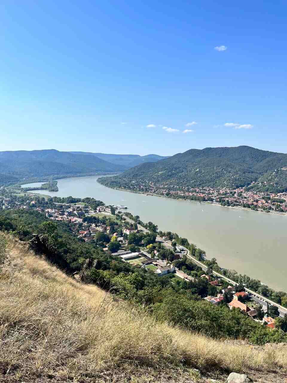 Panoramic view of the Danube Bend from Visegrád, with the river winding through hills and villages, representing a scenic day trip from Budapest.