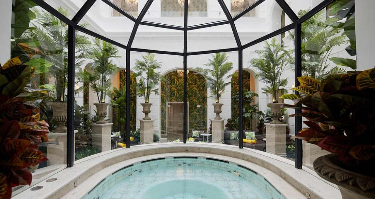 Indoor spa pool surrounded by greenery inside a luxury hotel in Budapest, representing a romantic hotel getaway with spa facilities.