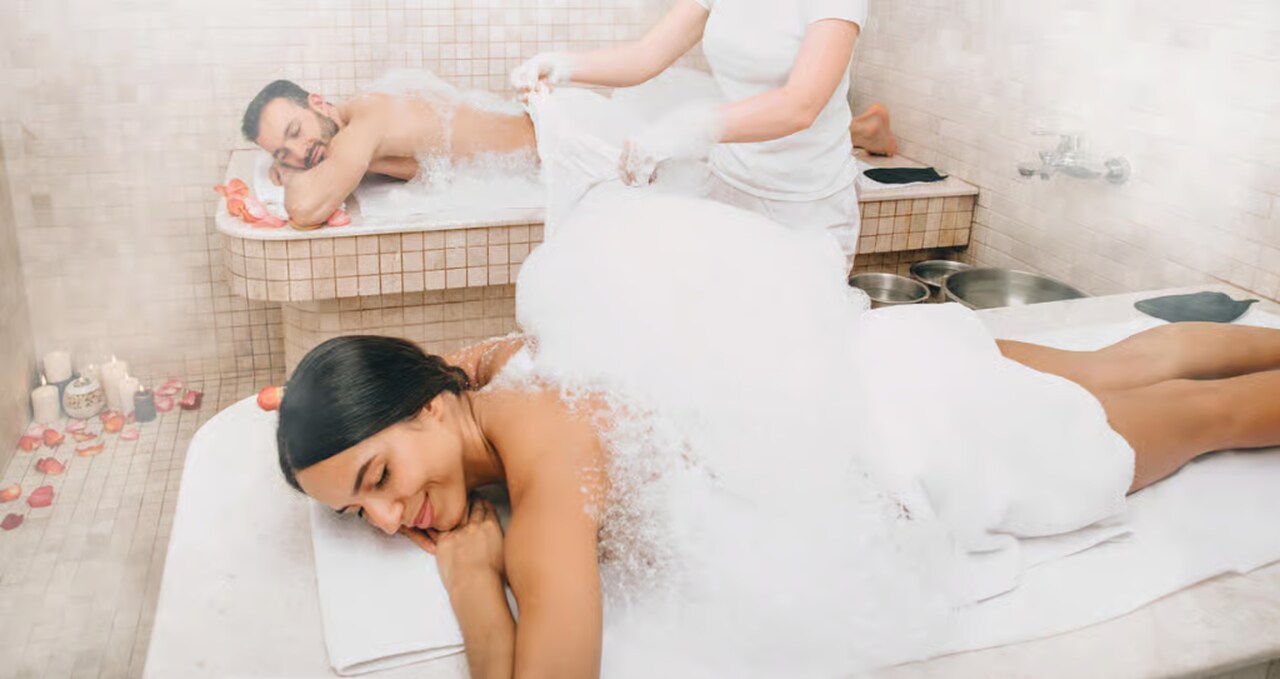 Couple enjoying a relaxing spa treatment with foam and massage beds in Budapest, representing a romantic couples massage experience for Valentine’s Day.