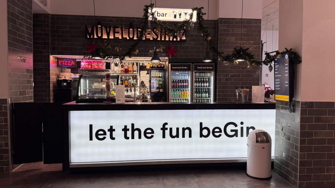 Bar area at a&o Hostel Budapest with drinks and pizza, part of the modern common areas for guests