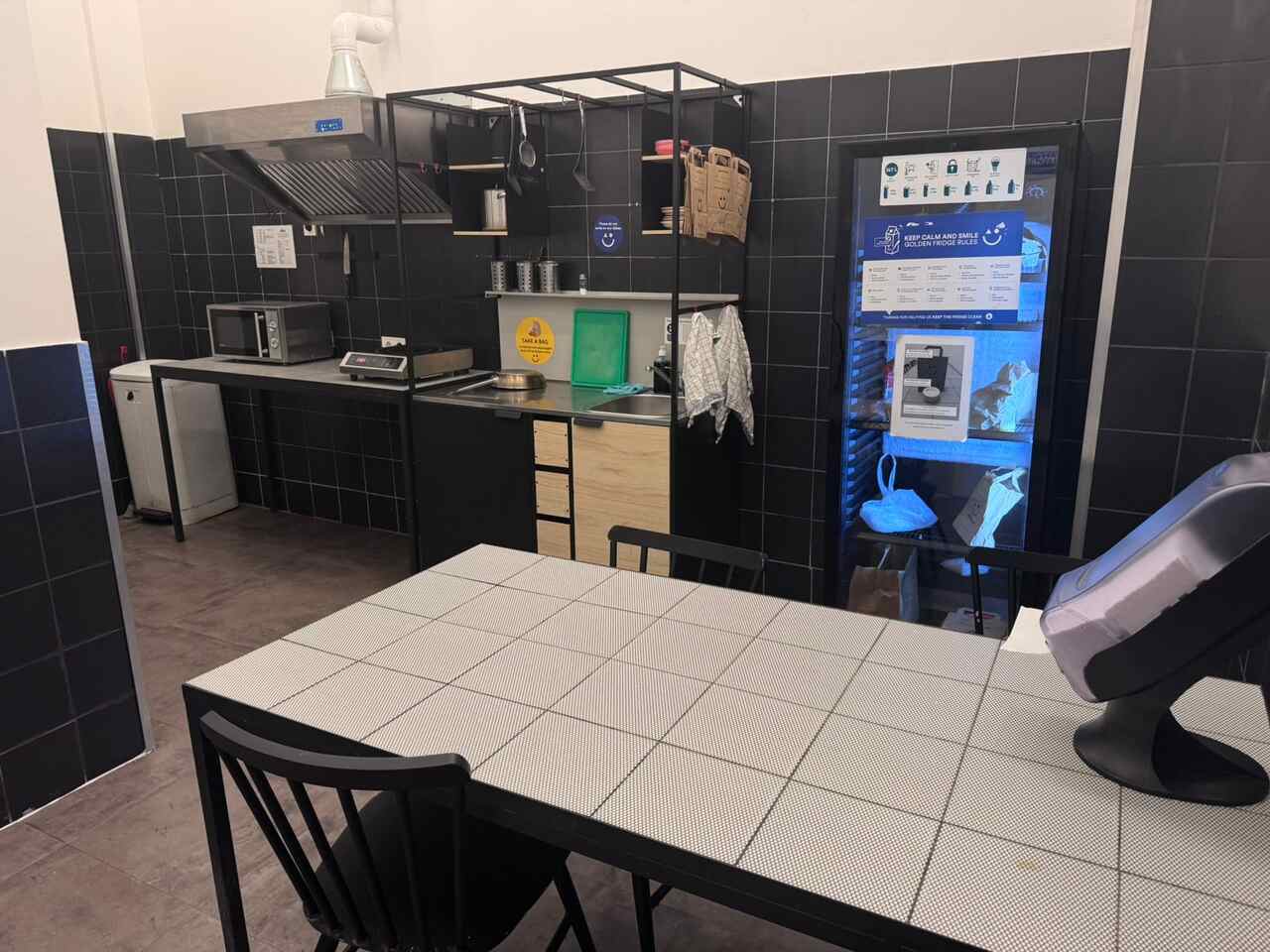 Shared kitchen at a&o Hostel Budapest with cooking equipment and dining table for guests